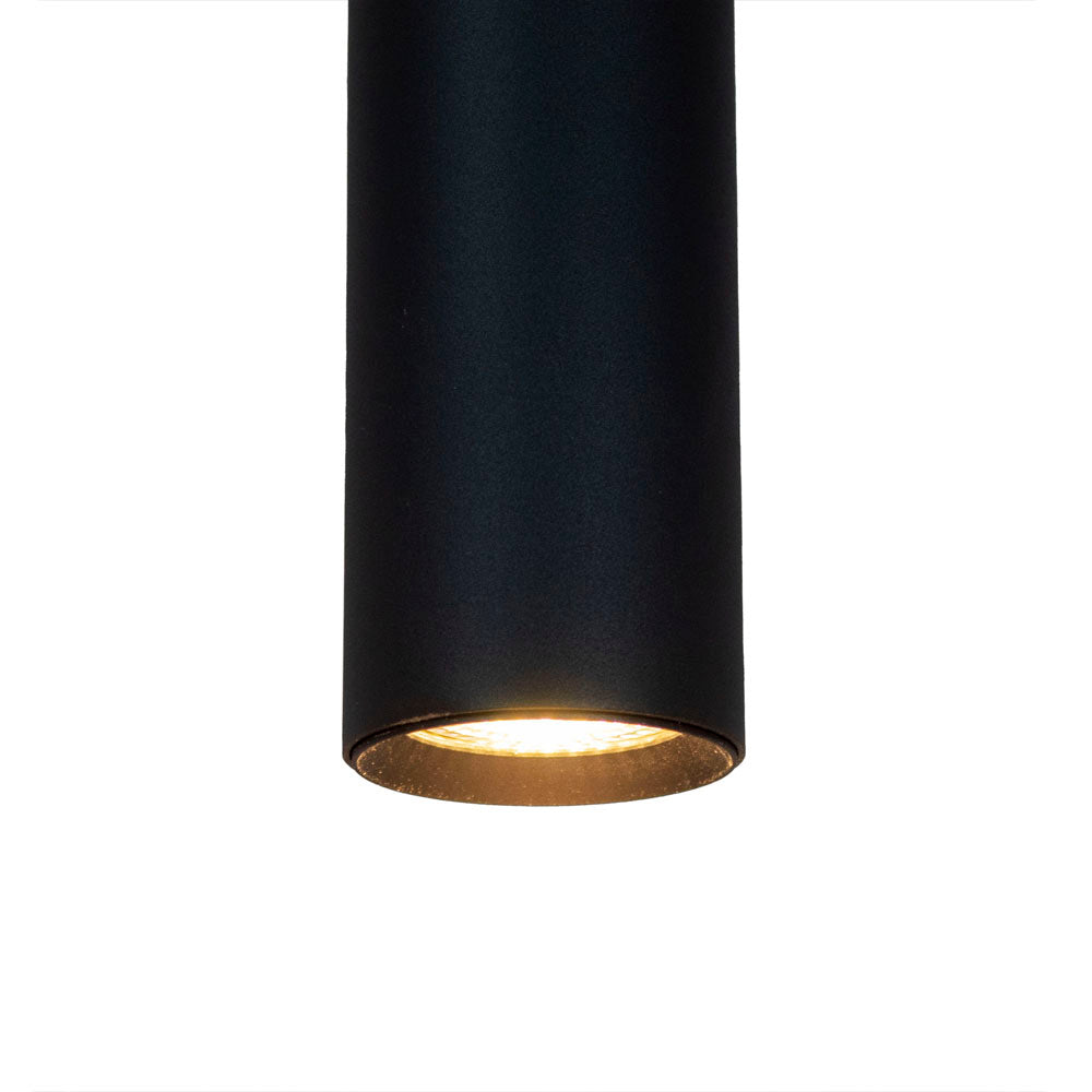 Zwarte cilindervormige opbouwspot met warme LED-verlichting, frontaal onderaanzicht tegen een witte achtergrond.