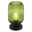 Groene glazen tafellamp met geribbelde structuur en zwarte ronde voet, frontaal aanzicht met warme lichtbron zichtbaar binnenin.