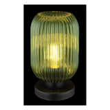 Groen geribbelde glazen tafellamp met zwarte ronde voet, brandend weergegeven in frontaal aanzicht tegen een zwarte achtergrond.