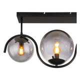 Close-up vooraanzicht van een moderne plafondlamp met twee glazen rookgrijze bollen en zwarte metalen armatuur, waarin zichtbare filamentlampen warm licht uitstralen.