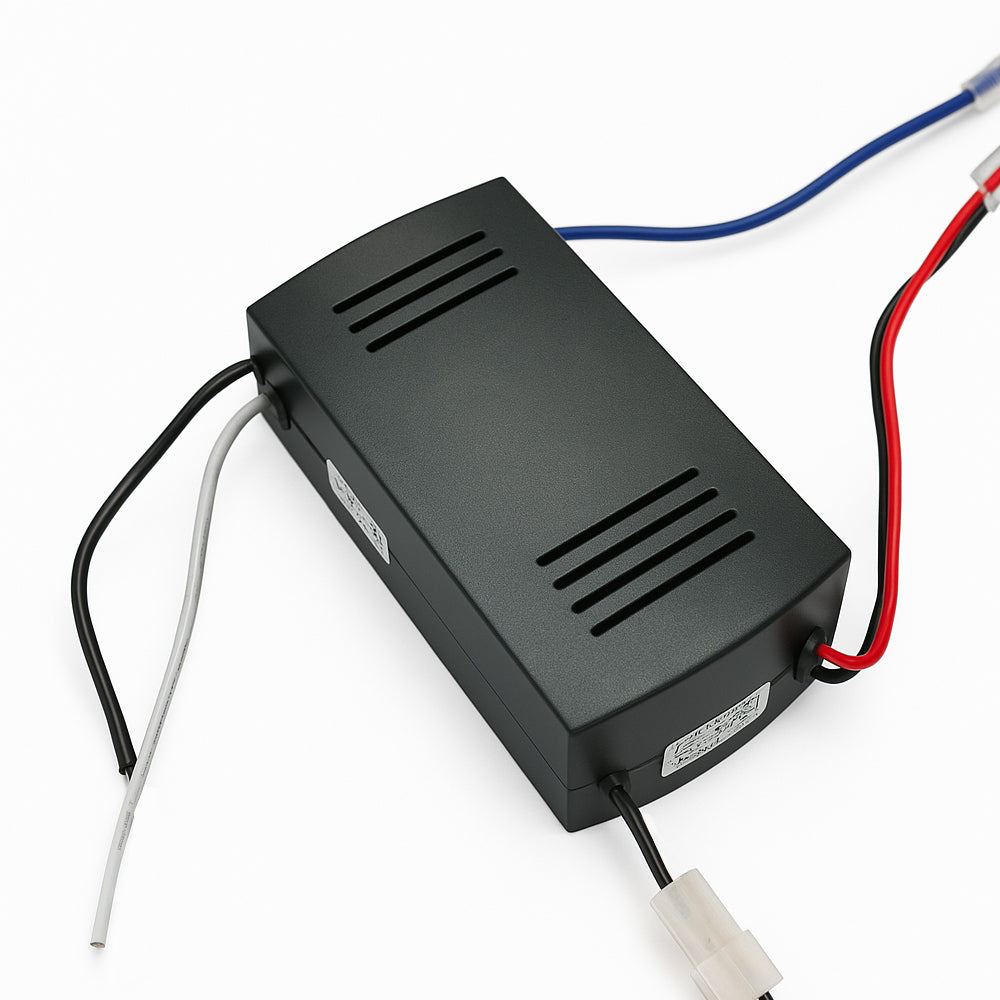 Zwarte elektronische transformator met ventilatiegleuven en meerdere aangesloten draden, schuin bovenaanzicht op witte achtergrond.