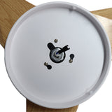 Detailweergave van de onderzijde van een ronde plafondlamp met houten afwerking, met zicht op het montagepunt en de elektrische bedrading.