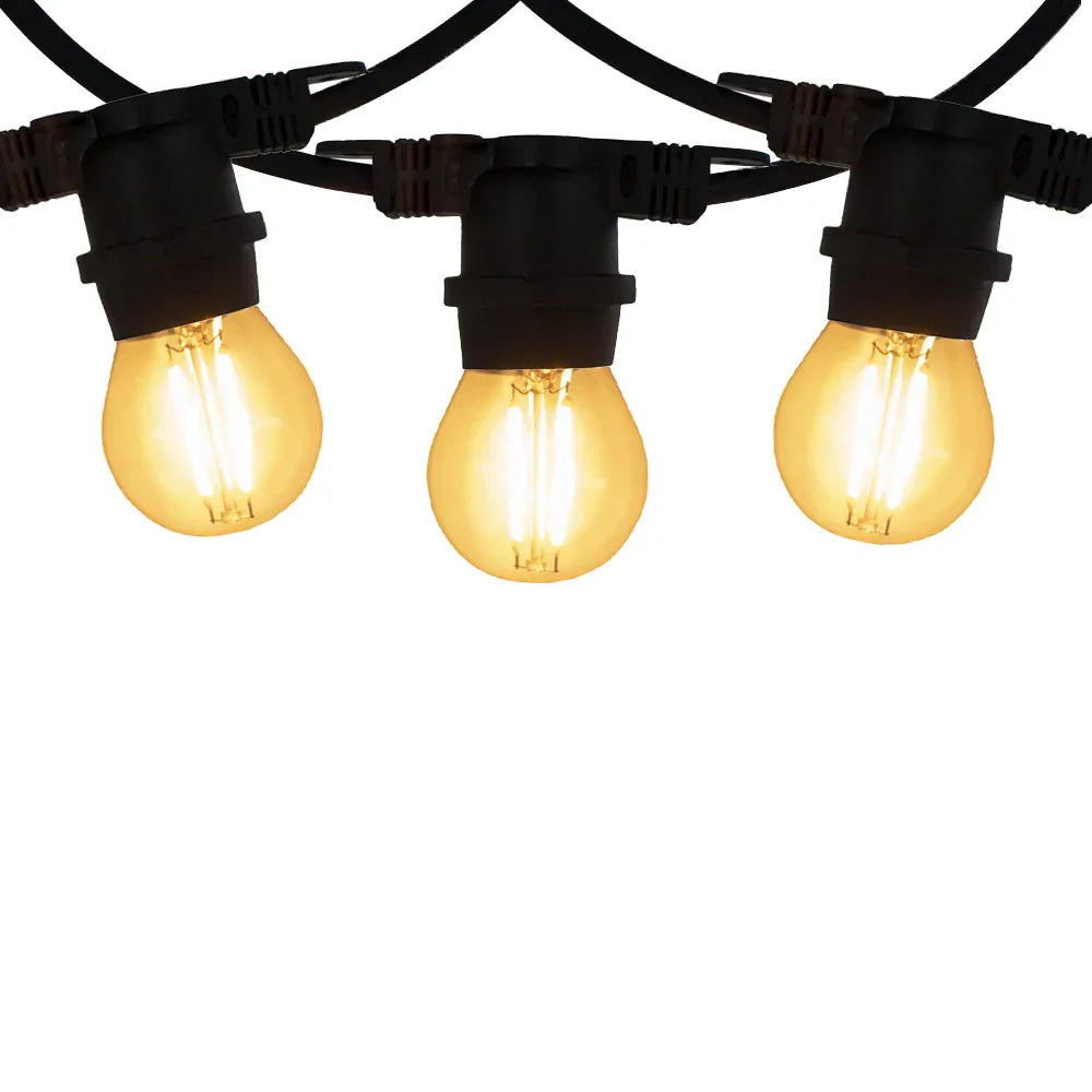 Close-up vooraanzicht van drie warm wit brandende LED filamentlampen aan een zwarte prikkabel, geschikt voor buitenverlichting of sfeervolle tuinverlichting.