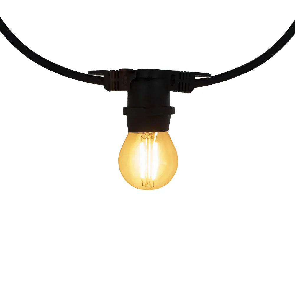 Close-up vooraanzicht van een brandende LED filament lamp in een zwarte fittingssnoer, geschikt als sfeervolle buitenverlichting voor tuin of terras.