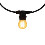 Close-up vooraanzicht van een brandende LED filament lamp in een zwarte fittingssnoer, geschikt als sfeervolle buitenverlichting voor tuin of terras.