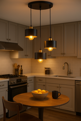 Moderne zwarte hanglampen met warme LED-verlichting boven een ronde houten eettafel in een sfeervolle, eigentijdse keuken – vooraanzicht.