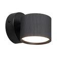 Moderne zwarte wandlamp met geribbelde cilindervormige kap en neerwaarts gericht licht, zijaanzicht.