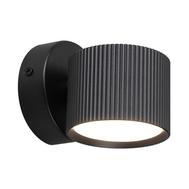 Moderne zwarte wandlamp met geribbelde cilindervormige kap en neerwaarts gericht licht, zijaanzicht.