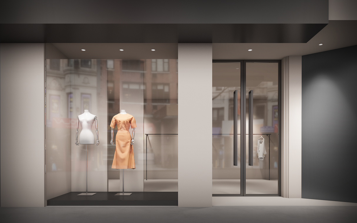 Etalageaanzicht van een moderne kledingwinkel met twee paspoppen, waarvan één gekleed is in een elegante perzikkleurige jurk, links in de vitrine; rechts een glazen winkeldeur met zicht op een minimalistisch interieur en een wit kledingstuk aan een hanger.