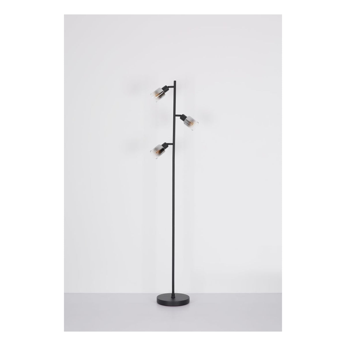 Staande lamp met drie verstelbare spots en zwarte metalen standaard, gefotografeerd in frontaal aanzicht tegen een neutrale witte achtergrond.