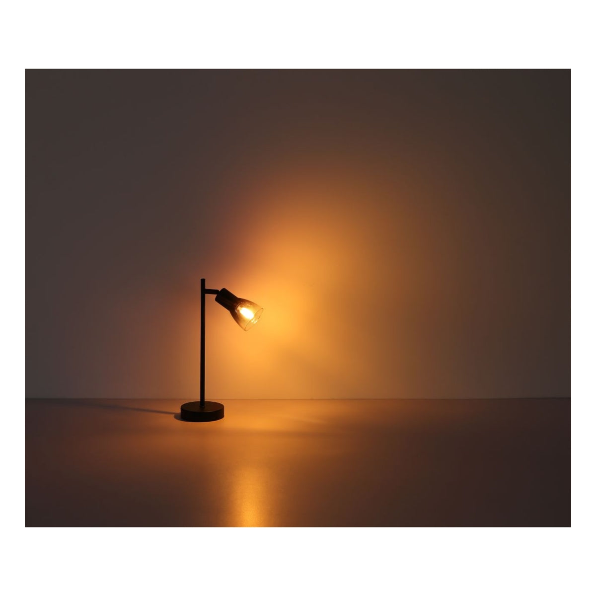Zijaanzicht van een moderne zwarte tafellamp met warme LED-verlichting, geplaatst op een glad oppervlak tegen een neutrale achtergrond, sfeervol verlichtend.