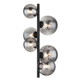Close-up vooraanzicht van een moderne wandlamp met zes rookglas bollen op een verticale zwarte metalen staaf, met zichtbare LED-lichtbronnen.