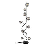 Staande design vloerlamp met zwarte metalen spiraalvormige standaard en meerdere rookglas bollen, frontaal aanzicht tegen witte achtergrond.