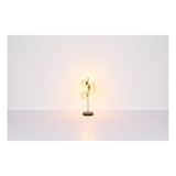 Moderne gouden tafellamp met zes glazen bollen, staande op een zwarte ronde voet, gefotografeerd recht van voren tegen een witte achtergrond.