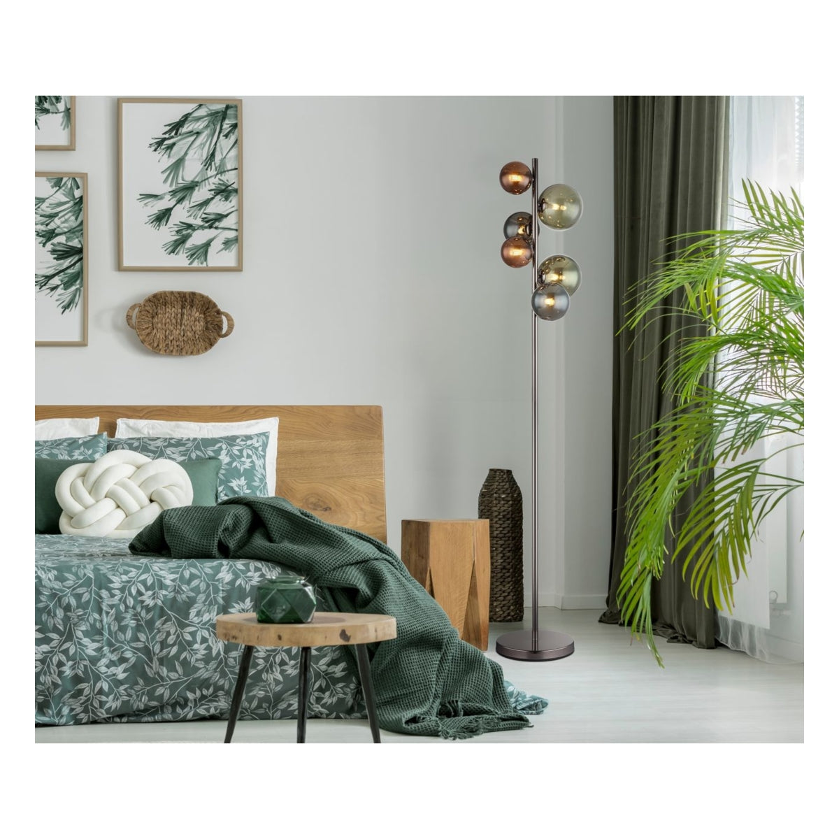 Staande vloerlamp met meerdere gekleurde glazen bollen in een moderne slaapkamer, vooraanzicht met groene accenten, houten meubels en natuurlijke decoratie.