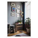 Staande vloerlamp met meerdere gekleurde glazen bollen in een modern interieur, zijaanzicht met daglicht en omringd door kamerplanten, meubels en wanddecoratie.