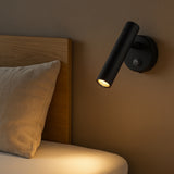 Zwart moderne wandlamp leeslamp naast bed met warm licht, gemonteerd aan muur boven hoofdbord, zijaanzicht.