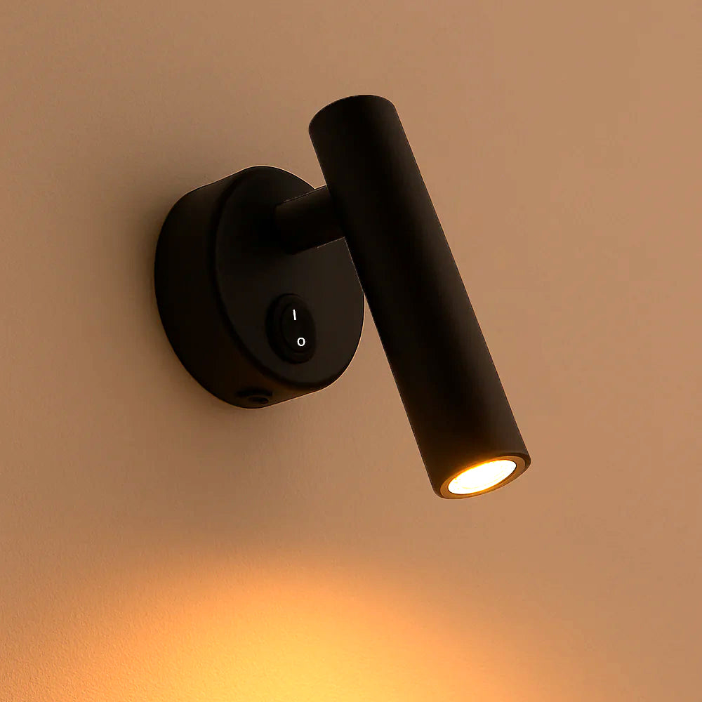 Zijaanzicht van een moderne zwarte LED leeslamp met wandmontage, schakelaar op de basis en warm wit licht, ideaal als bedlampje of wandverlichting.