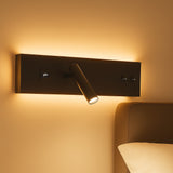 Moderne wandlamp met geïntegreerde leeslamp, USB-aansluiting en sfeervolle indirecte verlichting, gemonteerd boven een bed – zijaanzicht.