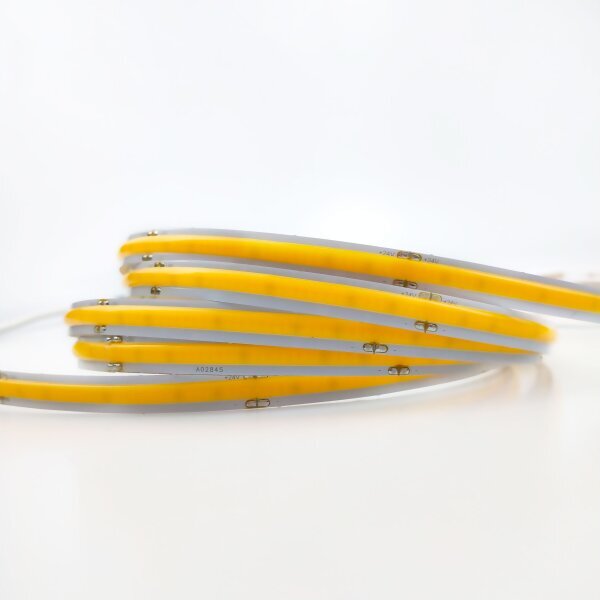 Flexibele COB LED strip in schelpvorm gevouwen, zijaanzicht met zichtbare gele LED-chipstructuur en witte stripbehuizing tegen een witte achtergrond.