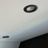 Zwarte ronde inbouwspot LED gemonteerd in wit plafond, schuin van onderen gefotografeerd ter illustratie van het design en de afwerking.