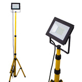 LED bouwlamp op statief met geel verstelbaar driepootstatief, vooraanzicht en schuinaanzicht van de lamp met rechthoekige behuizing en geïntegreerde LED-verlichting.
