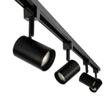Zwarte moderne railverlichting met drie verstelbare cilindervormige spots, schuin van onderen gefotografeerd voor een dynamisch perspectief.