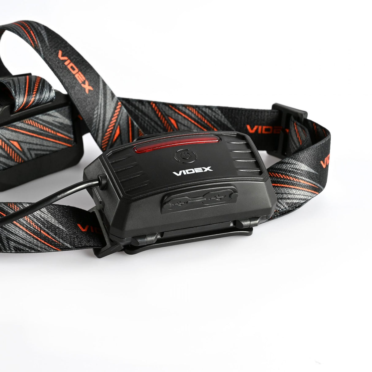 Close-up zijaanzicht van de Videx hoofdlamp met verstelbare hoofdband in zwart met roodgrijze accenten, ideaal voor outdoor activiteiten.