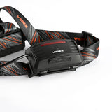 Close-up zijaanzicht van de Videx hoofdlamp met verstelbare hoofdband in zwart met roodgrijze accenten, ideaal voor outdoor activiteiten.