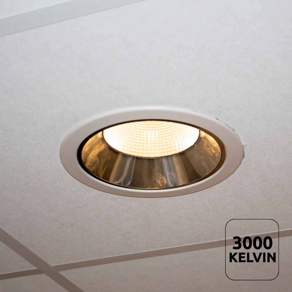Inbouw LED downlight met warm wit licht (3000 Kelvin) gemonteerd in systeemplafond, onderaanzicht.