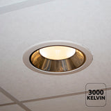 Inbouw LED downlight met warm wit licht (3000 Kelvin) gemonteerd in systeemplafond, onderaanzicht.