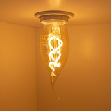 Close-up van een brandende decoratieve LED filamentlamp met spiraalvormig patroon, gemonteerd aan het plafond, gezien vanaf de zijkant met warme sfeerverlichting.