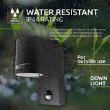 Waterdichte buitenlamp met bewegingssensor, IP44 rating, zwarte wandmontage downlight – schuin zijaanzicht met regendruppels, geschikt voor buitengebruik.