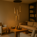 Moderne woonkamer met warm bruine tinten, centraal een houten salontafel met decoratieve schalen, omringd door beige fauteuils en een bank; vanuit plafond zicht op hanglamp met cilindervormige, goudkleurige armaturen; rechter aanzicht toont ingebouwde boekenkast met boeken als decoratie.