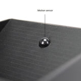 Close-up van een zwarte bewegingssensor op de bovenkant van een elektronisch apparaat, met duidelijk zichtbare textuur en label "Motion sensor".
