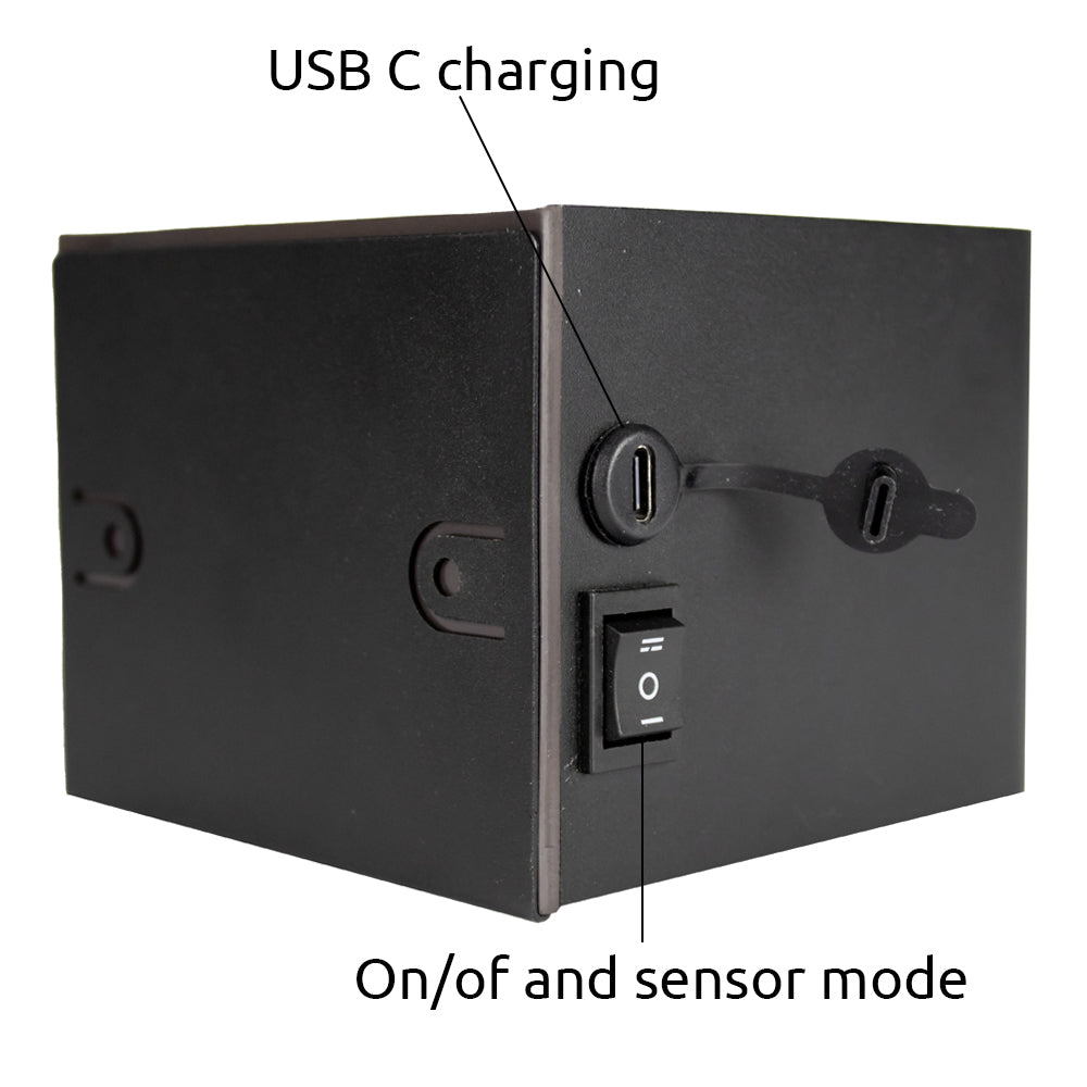 Close-up zijaanzicht van een zwarte wandlamp met USB-C oplaadpoort en aan/uit schakelaar met sensorfunctie.