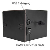 Close-up zijaanzicht van een zwarte wandlamp met USB-C oplaadpoort en aan/uit schakelaar met sensorfunctie.