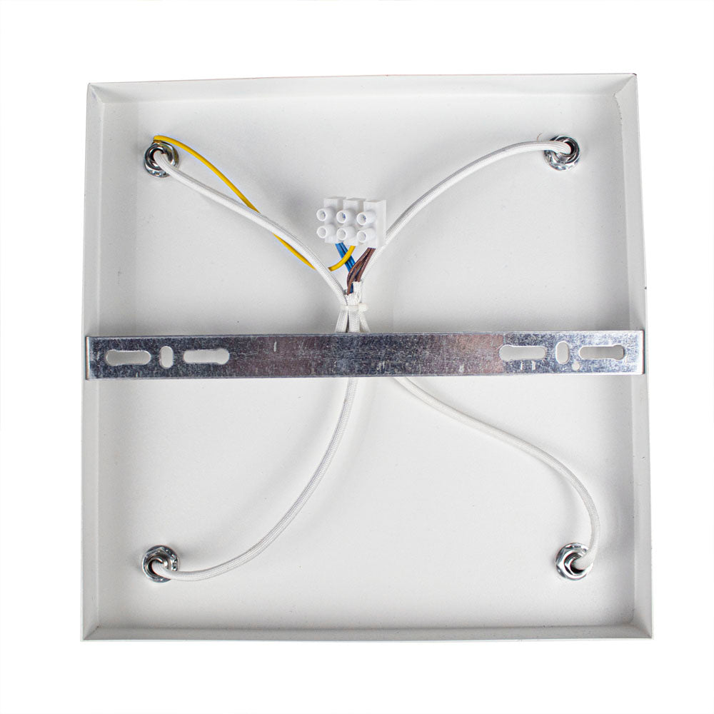 Achteraanzicht van een vierkante plafondlampbehuizing met metalen montagemontage, witte stroomkabels en een kroonsteentje voor elektrische aansluiting.