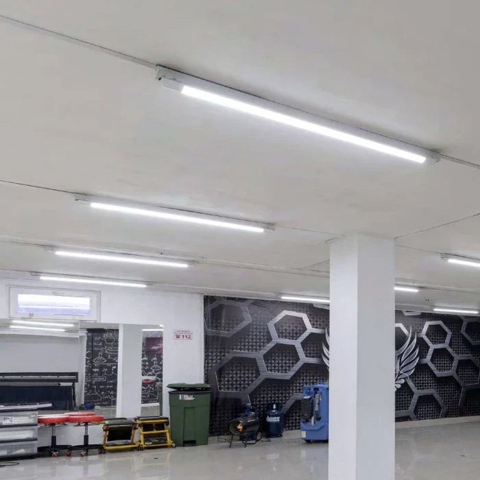 LED TL Buisverlichting gemonteerd aan het plafond in een moderne garage of werkplaats – binnenaanzicht met helder wit licht en industrieel interieur.