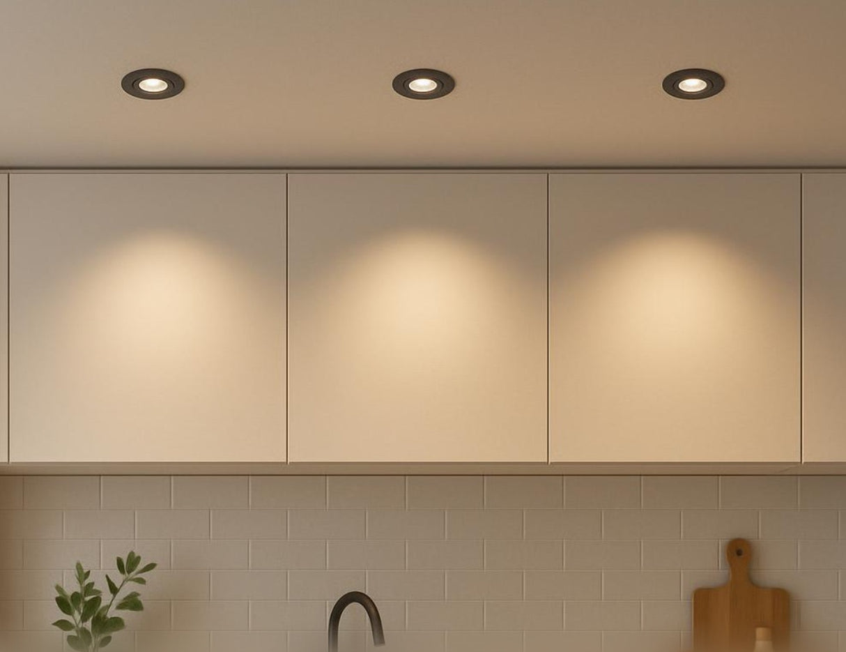 Inbouwspot Zwart LED – vooraanzicht van drie zwarte LED inbouwspots in een moderne keukenplafond, met zachte warme verlichting boven beige keukenkasten en witte tegelwand.