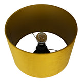Bovenaanzicht van een moderne gele lampenkap met fluwelen afwerking en zichtbare gloeilamp en fitting.