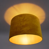 Gele velvet plafondlamp met warme lichtuitstraling, gezien van schuin-onderaanzicht tegen een neutrale achtergrond.