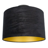 Zwarte velvet lampenkap met gouden binnenzijde, cilindervormig design, vooraanzicht schuin van onderen genomen.
