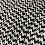 Close-up van zwart-wit gevlochten polyester touw met zigzagpatroon, in perspectief schuin van voren genomen.