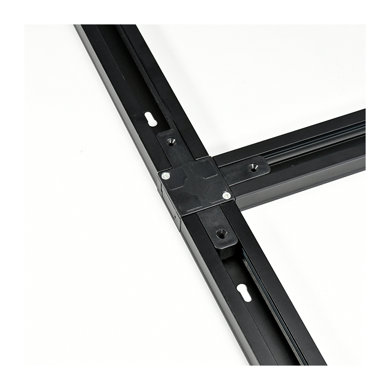 Detailaanzicht van een zwarte metalen verbindingshoek van een aluminium profiel-framesysteem, met zicht op de bevestigingsschroeven en montagesleuf, tegen een witte achtergrond.