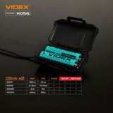 Afbeelding van een open zwarte batterijhouder met twee oplaadbare Videx 18650 Li-ion 2200mAh batterijen, van bovenaf gezien, met specificatietabel van de Videx H056 hoofdlamp op de achtergrond.