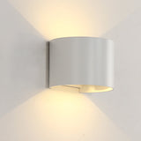 Moderne witte wandlamp met omhoog en omlaag schijnend licht, cilindrisch ontwerp, zijaanzicht tegen een witte muur.