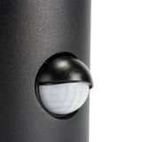 Close-up zijaanzicht van een zwarte buitenlamp met geïntegreerde witte bewegingssensor, geschikt voor wandmontage en voorzien van een gebogen beschermkap.