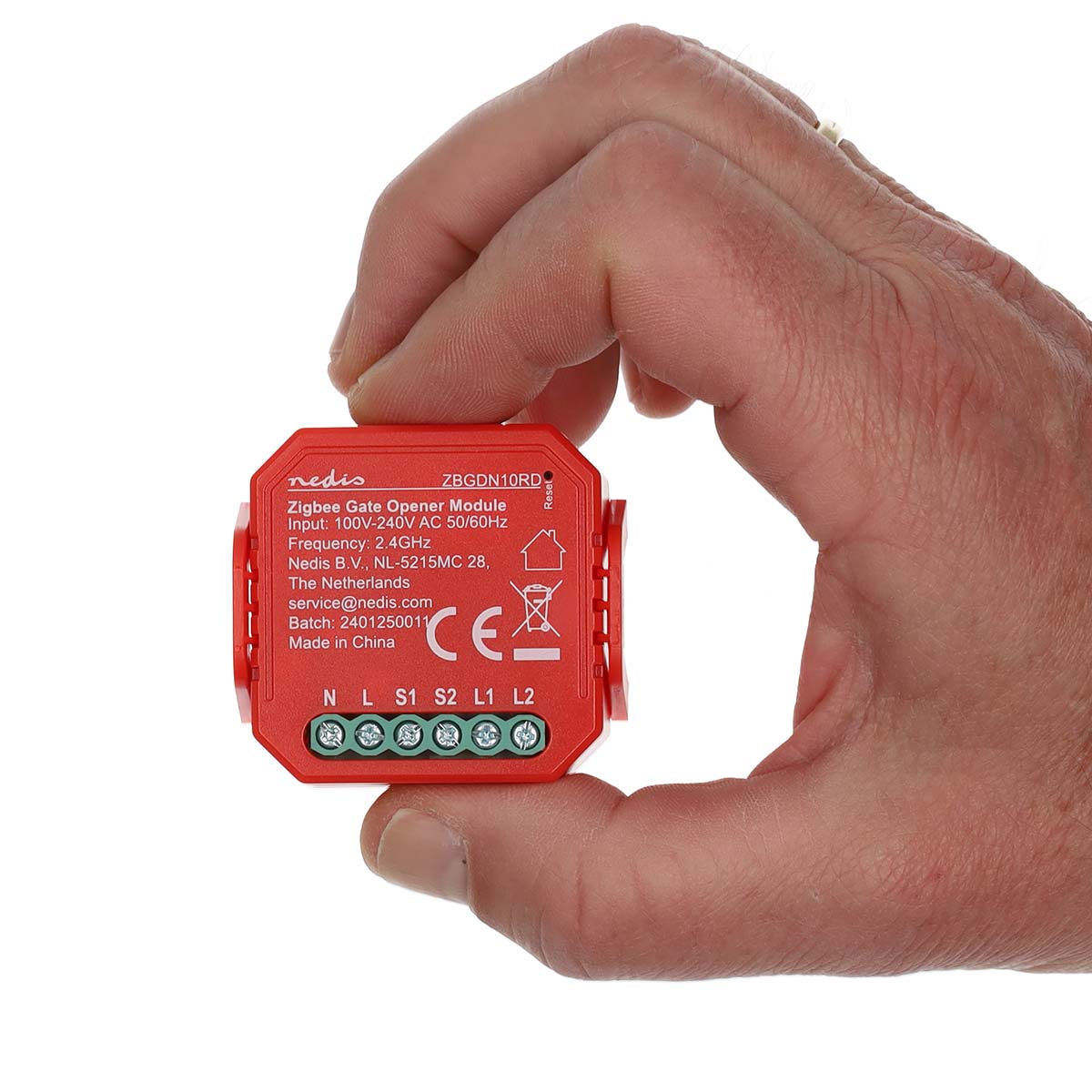 Close-up vooraanzicht van een hand die de rode Nedis Zigbee Gate Opener Module (model ZBGDN10RD) vasthoudt, met zicht op specificaties, aansluitpunten en productinformatie op de voorkant van het apparaat.