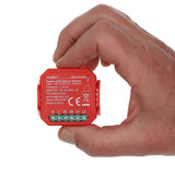 Close-up vooraanzicht van een hand die de rode Nedis Zigbee Gate Opener Module (model ZBGDN10RD) vasthoudt, met zicht op specificaties, aansluitpunten en productinformatie op de voorkant van het apparaat.